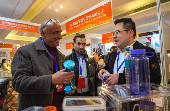 An Iraqi merchant (first on left) buys Chinese water bottles in a market in Taizhou, east China's Zhejiang province, Feb. 24, 2023. (Photo by Zhang Yongtao/People's Daily Online)