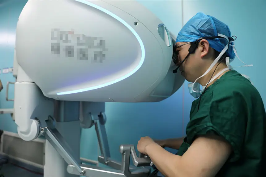 A surgeon performs an operation under the assistance of a surgery robot. (Photo courtesy of the publicity department of the Communist Party of China Xiushui county committee)