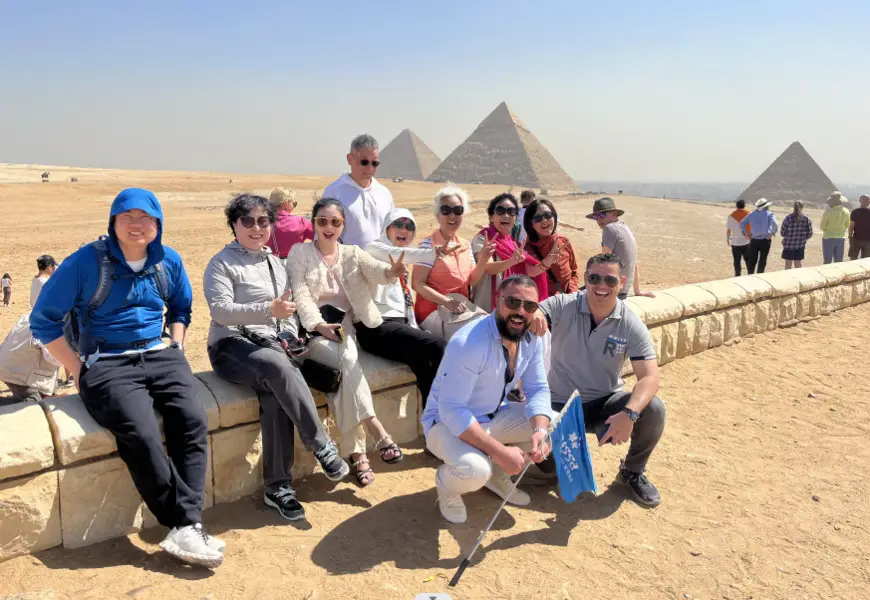 Chinese tourists pose for a picture with local hosts in front of pyramids in Egypt. (Photo from the official account of travel agency Caissa Touristic on WeChat)