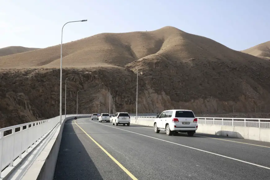 Photo taken on Nov. 10, 2021 shows vehicles running on a bridge completed during the second phase of a new North-South highway project in Kazarman of Jalalabad Region, Kyrgyzstan. (Photo by Roman/Xinhua)