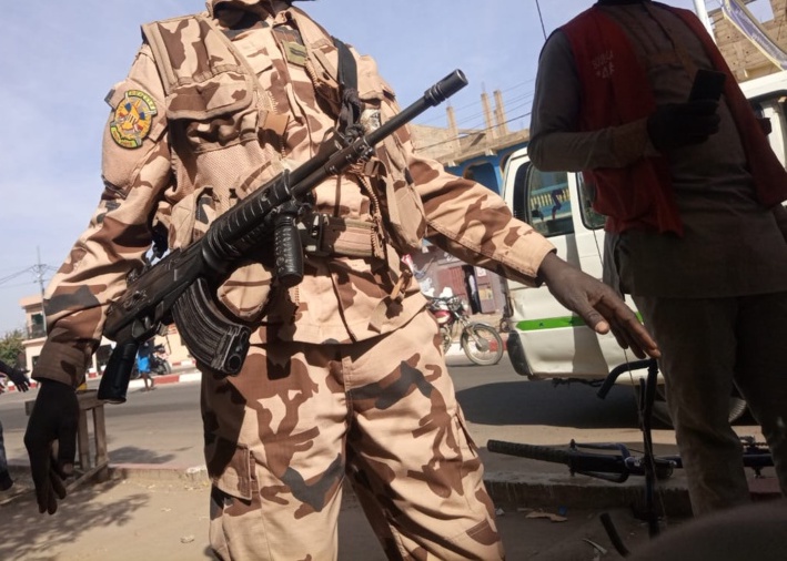 Un militaire de la garde présidentielle renvoie des vendeurs ambulants pour sécuriser le passage du cortège du président de transition à N'Djamena. Illustration © T.O./Alwihda Info