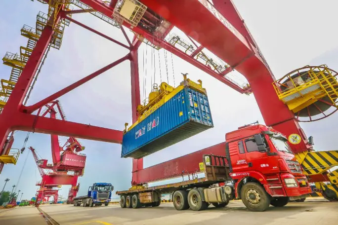 Containers are unloaded from trucks at the Zhengpu port in Ma'anshan, east China's Anhui province, July 3. (Photo by Wang Wensheng/People's Daily Online)