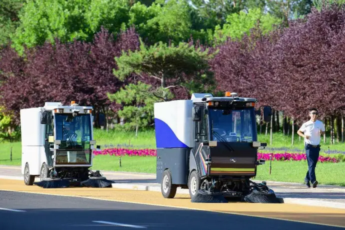 Self-driving street cleaning vehicles work in a street in Ordos, north China's Inner Mongolia autonomous region. (Photo by Wang Zheng/People's Daily Online)