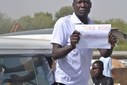 Un jeune homme brandit un message lors de la marche d'aujourd'hui à N'Djamena. Crédit photo : L'Union Un jeune homme brandit un message lors de la marche d'aujourd'hui à N'Djamena. Crédit photo : L'Union
