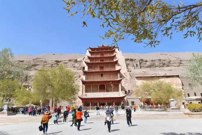 Tourists visit the Mogao Grottoes in Dunhuang, northwest China's Gansu province. (Photo by Wang Binyin/People's Daily Online)