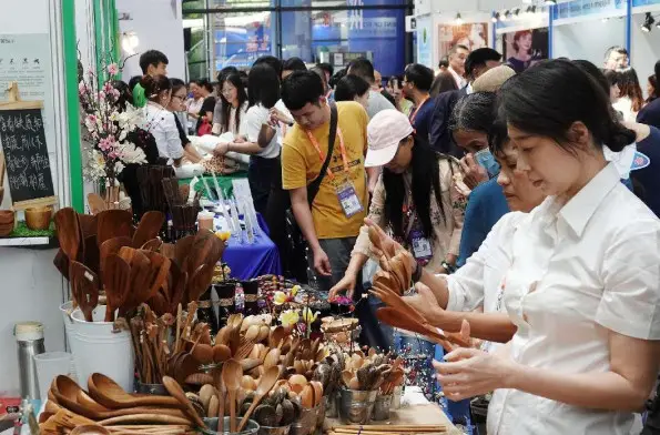 Visitors to the 20th China-ASEAN Expo, which is held in Nanning, south China's Guangxi Zhuang autonomous region, shop wooden handicrafts made in Thailand, Sept. 16, 2023. (Photo by Yu Xiangquan/People's Daily Online)