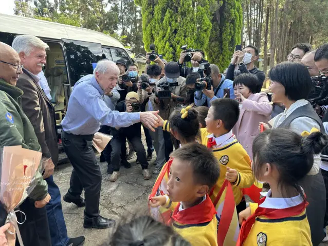 A descendant of a Flying Tigers veteran interacts with local primary school students when visiting the former residence of the Flying Tigers in Kunming, southwest China's Yunnan province. (Photo by Liu Lingling/People's Daily)