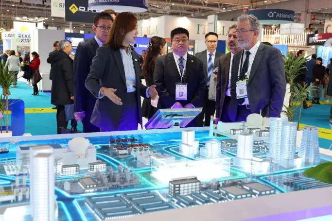 An employee of China National Nuclear Corporation introduces the corporation's exhibition to the head of the French Alternative Energies and Atomic Energy Commission at the 5th World Nuclear Exhibition held in Paris, France in November 2023. (Photo by Shang Kaiyuan/People's Daily)