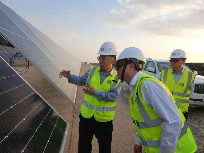 Staff member gives a brief to the Al Shuaibah Solar PV Project undertaken by a Chinese company in Saudi Arabia, the world's largest solar power station currently under construction. (Photo by Guan Kejiang/People's Daily)