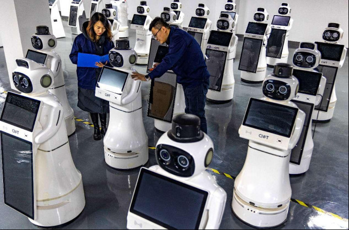 Technicians debug reception robots in a workshop of a tech firm in Zhangye, northwest China's Gansu province. (Photo by Yang Xiao/People's Daily Online)