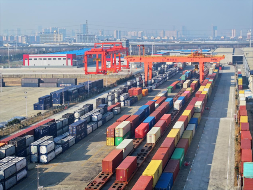 A gantry crane hoists containers at a logistics base in Hai'an, east China's Jiangsu province. (Photo by Xu Congjun/People's Daily Online)