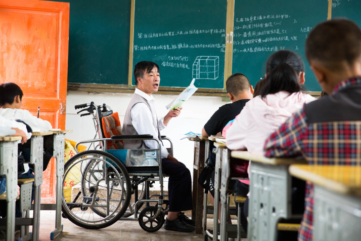 Zhang Jiasong (center), a teacher in Lingjiao Primary School in Dafang County, Guizhou Province in southwest China, gives a lesson to students. (XINHUA)