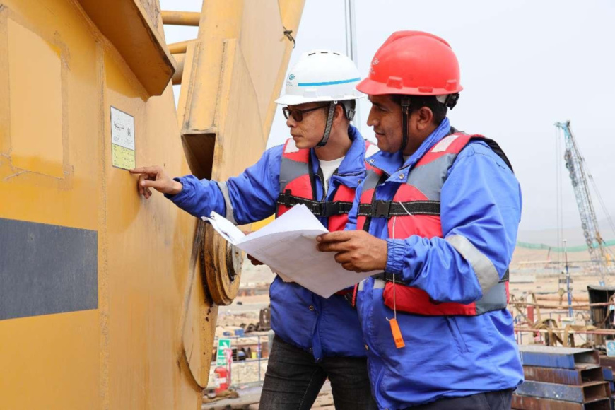 Chinese and Peruvian employees perform equipment maintenance at the construction site of the Chancay Port. (Photo by Qiu Yan) Chinese and Peruvian employees perform equipment maintenance at the construction site of the Chancay Port. (Photo by Qiu Yan)