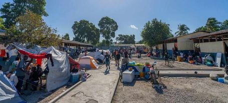 © IOM/Antoine Lemonnier. Un groupe de personnes déplacées hébergées dans une école du centre de Port-au-Prince, sur le site Jean-Marie Vincent.
