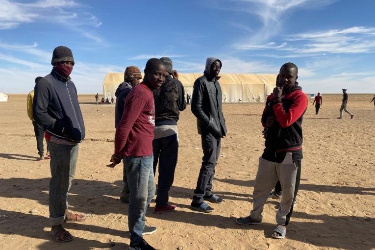 Un groupe de jeunes hommes attendent pour recevoir de la nourriture à Assamaka, après avoir été expulsés d'Algérie, en mars 2021. Crédit : Mariama Diallo/MSF Un groupe de jeunes hommes attendent pour recevoir de la nourriture à Assamaka, après avoir été expulsés d'Algérie, en mars 2021. Crédit : Mariama Diallo/MSF
