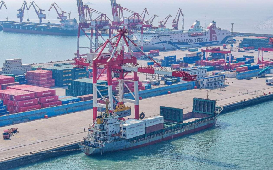 Containers are loaded to and unloaded from cargo vessels at an important transfer hub for cross-border e-commerce in Rongcheng, east China's Shandong province. (Photo by Li Xinjun/People's Daily Online)