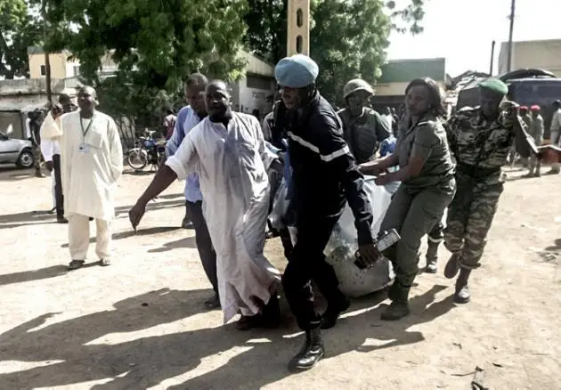 AFP/AFP - Des forces de sécurité évacuent un corps après un attentat-suicide à Maroua, la capitale de l'Extrême-nord du Cameroun, le 22 juillet 2015