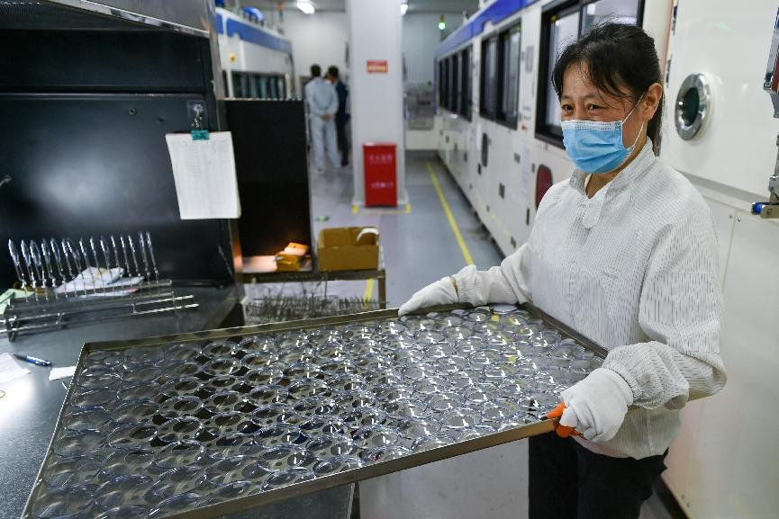 A worker works in an optical lens factory in Danyang, east China's Jiangsu province. (Photo by Fang Dongxu/People's Daily Online) A worker works in an optical lens factory in Danyang, east China's Jiangsu province. (Photo by Fang Dongxu/People's Daily Online)