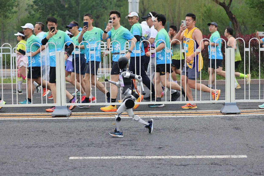 On April 19, 2025, Beijing humanoid robot half marathon kicks off, marking the first time in the world that robotic and human participants run along the same route on separate tracks. (Photo by Feng Junshan/People's Daily Online)