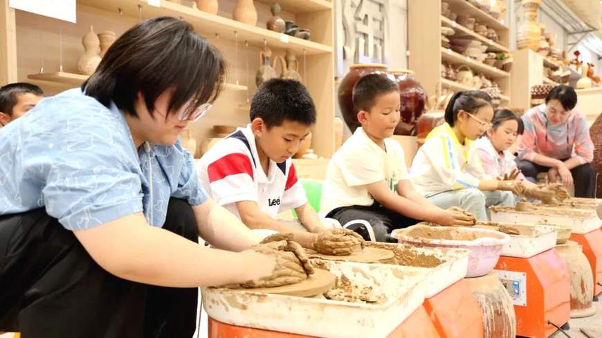 Children experience traditional clay making in an intangible cultural heritage workshop in Kuqa, northwest China's Xinjiang Uygur autonomous region. (Photo by Wang Xueni)