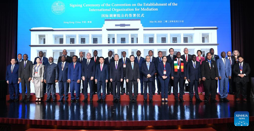 Chinese Foreign Minister Wang Yi, also a member of the Political Bureau of the Communist Party of China Central Committee, poses for a group photo with other guests at the signing ceremony of the Convention on the Establishment of the International Organization for Mediation (IOMed) in Hong Kong, south China, May 30, 2025. The signing ceremony was held here on Friday. Wang Yi attended the ceremony and delivered a speech. (Xinhua/Chen Duo) Chinese Foreign Minister Wang Yi, also a member of the Political Bureau of the Communist Party of China Central Committee, poses for a group photo with other guests at the signing ceremony of the Convention on the Establishment of the International Organization for Mediation (IOMed) in Hong Kong, south China, May 30, 2025. The signing ceremony was held here on Friday. Wang Yi attended the ceremony and delivered a speech. (Xinhua/Chen Duo)