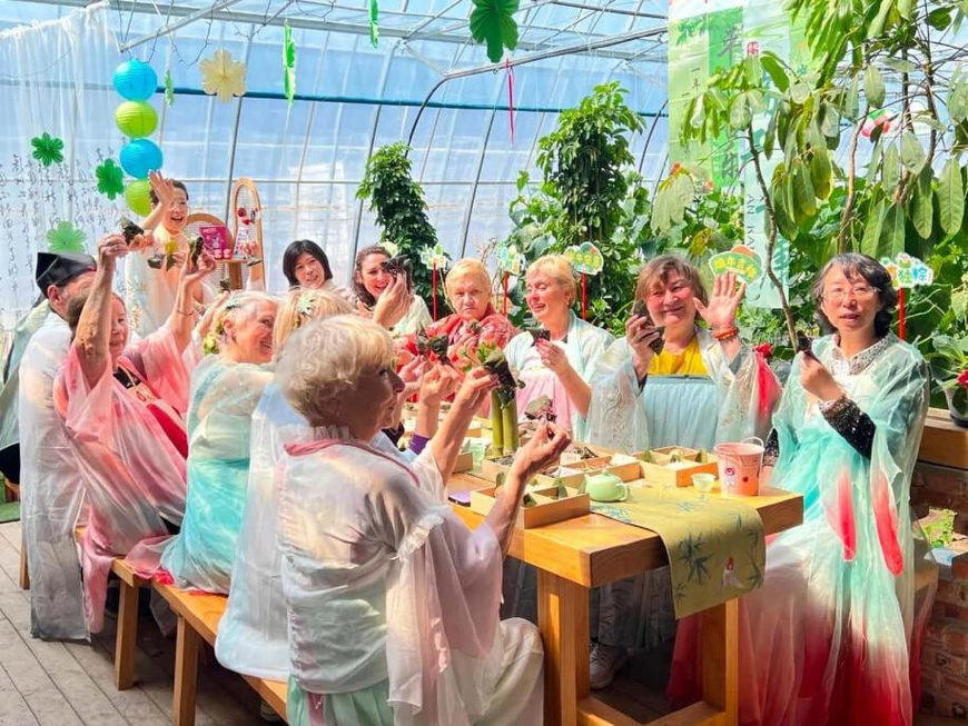 Russian guests make zongzi, a glutinous rice dumpling wrapped in bamboo or reed leaves to mark China's Dragon Boat Festival, with local residents in Nanhan village, Funing township, Suifenhe, northeast China's Heilongjiang province. (Photo by Zhang Chao)