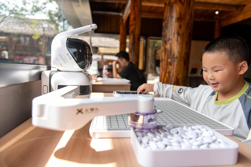 A boy plays go with an AI-powered robot at a tourist site in Congjiang county, southwest China's Guizhou province, Aug. 9, 2025. (Photo/Wu Dejun) A boy plays go with an AI-powered robot at a tourist site in Congjiang county, southwest China's Guizhou province, Aug. 9, 2025. (Photo/Wu Dejun)