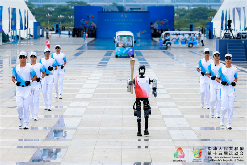A humanoid robot carries the torch of the 15th National Games in Shenzhen, south China's Guangdong province.