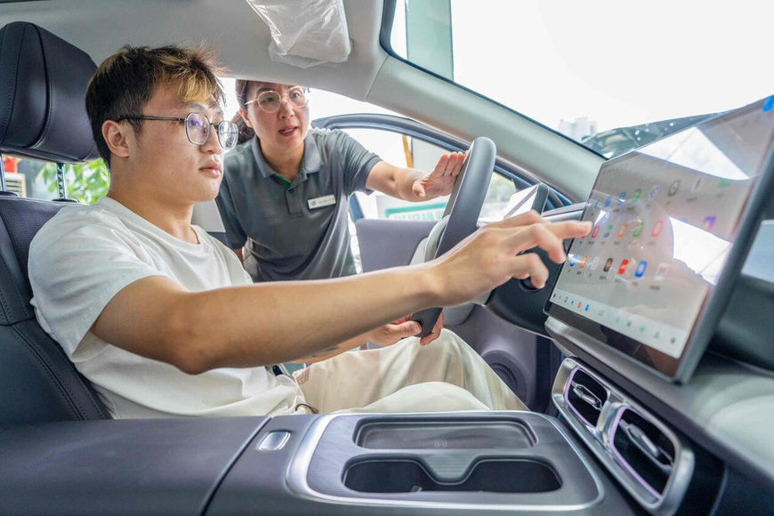A man experiences vehicle features at an automobile dealership in Hai'an, east China's Jiangsu province. (Photo/Zhai Huiyong)