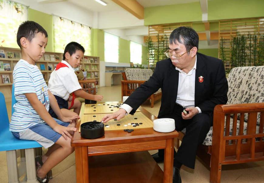Nie Weiping plays a match against two young players in Tongling, east China's Anhui province, Aug. 25, 2017. (Photo/Gao Lingjun)