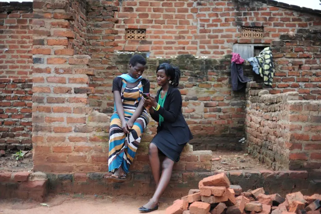 Sarah Bafumda chercheuse ougandaise des jeunes (adroite) partage des informations de la recherche du rapport Invisible Lives: Understanding Youth Livelihoods in Ghana and Uganda avec Hamidah Nyanzi interrogee pour letude. Credit photo: Intersect/Jennifer Huxta pour The MasterCard Foundation