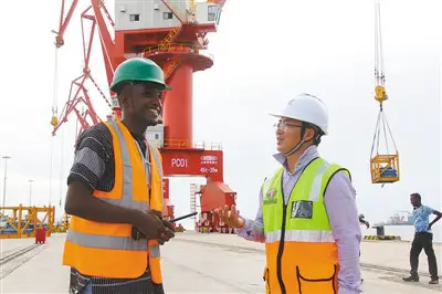 Pic: Two managers fromChina and Djibouti exchange views on a newly-built dock. (Photo by Li Zhiwei from People’s Daily)