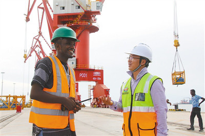 Chinese and Djiboutian administrative staff exchange views on a new dock built by China Merchants Group Limited (CGM) in the port in western suburb of Djibouti. The multi-functional Doraleh dock has greatly improved the competence of the port. (Photo by Li Zhiwei from People’s Daily)