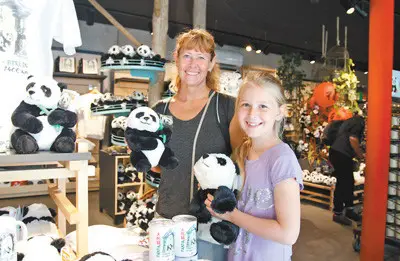 Tourists from Denmark are delightedly selecting Chinese panda themed souvenirs in a gift shop of the Berlin Zoo. (Photo by Guan Kejiang from People’s Daily)