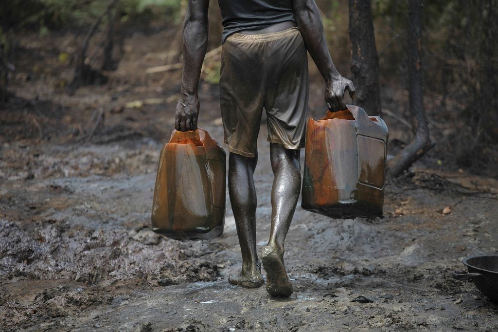 Dans une raffinerie illégale. Au Nigeria, des milliers de personnes participent à ce détournement de pétrole, connu localement sous le nom de "bunkering", qui consiste à trouer les pipelines pour voler du pétrole brut, qu'ils raffinent ou vendent directement. REUTERS/AKINTUNDE AKINLEYE Dans une raffinerie illégale. Au Nigeria, des milliers de personnes participent à ce détournement de pétrole, connu localement sous le nom de "bunkering", qui consiste à trouer les pipelines pour voler du pétrole brut, qu'ils raffinent ou vendent directement. REUTERS/AKINTUNDE AKINLEYE