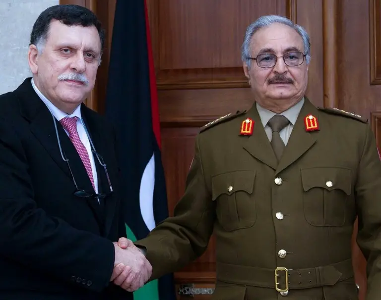 Le maréchal Khalifa Haftar (g) et le chef du gouvernement d'union nationale, Fayez al-Sarraj, le 31 janvier 2016 à Al-Marj / © Service de presse des forces armées libyennes/AFP/Archives /