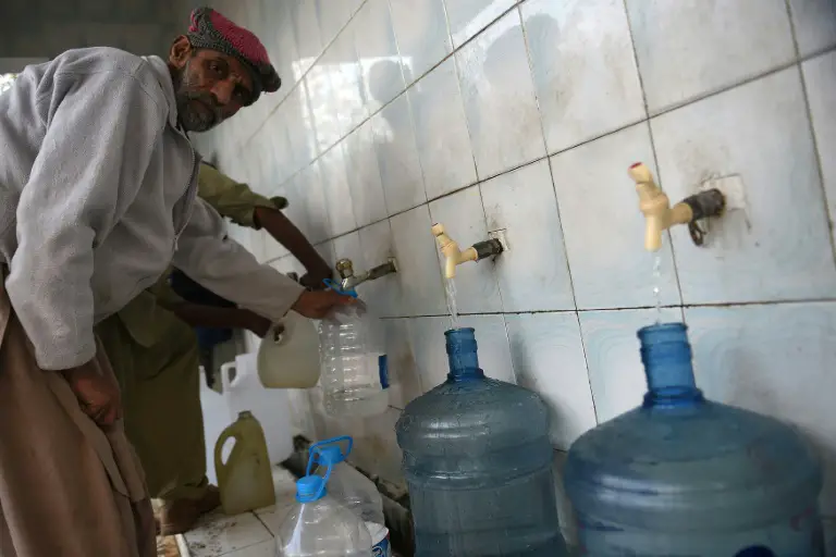 Un homme remplit des bouteilles d'eau dans une station de traitement à Islamabad, le 14 décembre 2017 / © AFP/Archives / Farooq NAEEM