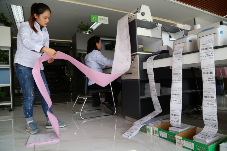A staff of a poverty alleviation park in central China’s Henan province print online orders of iron stick yams. (Photo by Xu Hongxing from CFP)