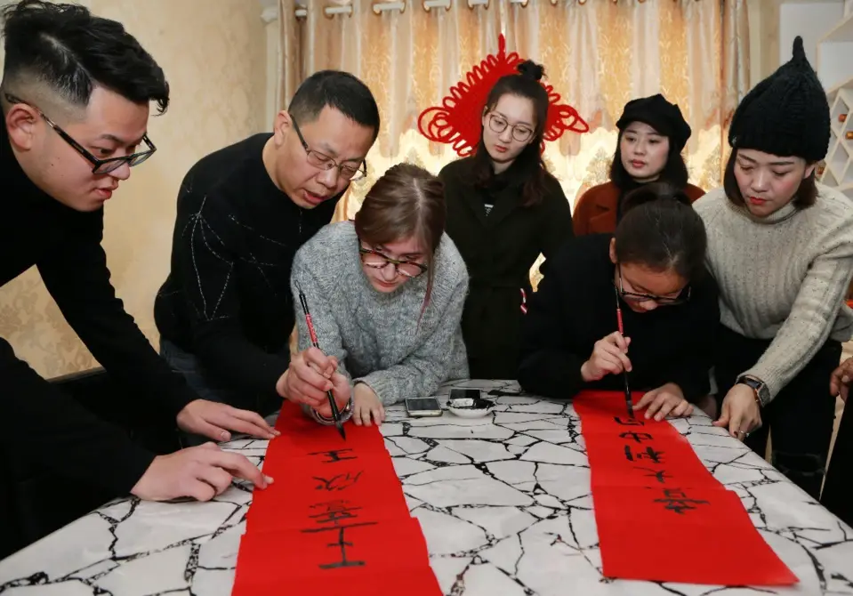 Foreign students learn to write Spring Festival couplets during the Chinese New Year. (Photo from People’s Daily Online)