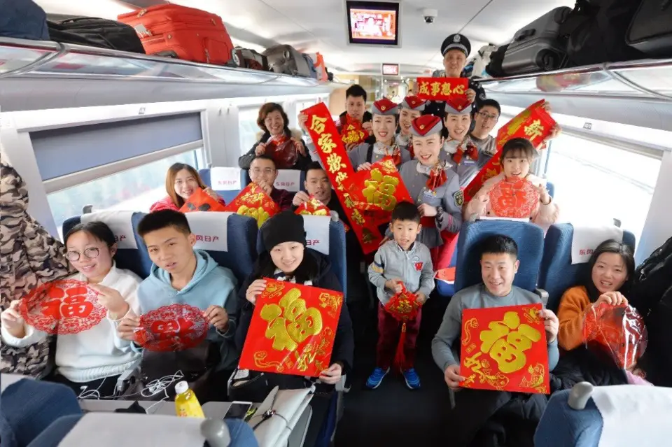 Crews and passengers on G182 high-speed train from Qingdao to Beijing celebrate the Spring Festival on the last day of lunar new year, Feb. 15, 2018. (CFP photo by Wang Haibin)