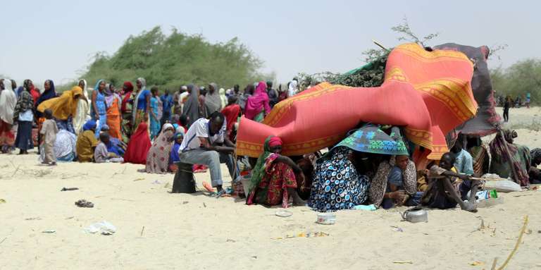 Une photographie du programme alimentaire mondial montre des dizaines de personnes évacuées des îles nigériennes du lac Tchad, sous des tentes de fortune, à N'Guigmi le 5 mai 2015. CRÉDITS : - / AFP