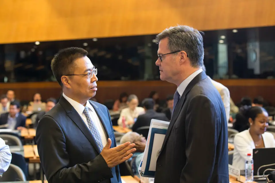 Ambassador Zhang Xiangchen, China’s permanent representative to the WTO and Ambassador Dennis Shea, the US permanent representative to the WTO, exchanged views just before the meeting. (File photo)