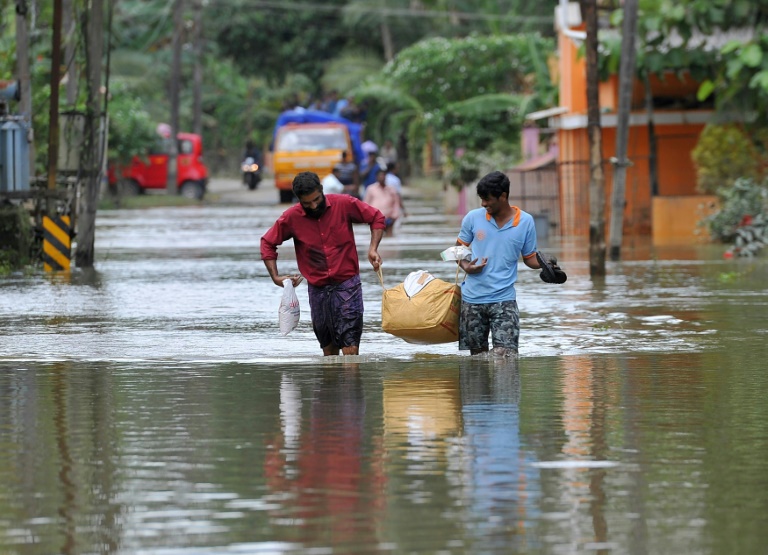 Des Indiens transportent de la nourriture et de l'eau pour les déplacés des inondations, dans le district d'Alappuzha, dans l'état indien du Kerala, le 21 août 2018 / © AFP/Archives / MANJUNATH KIRAN