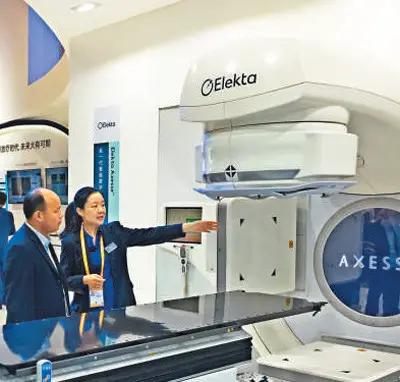 An employee of Elekta introduces the Elekta Axesse, the company’s newest smart digital platform for radiation therapy of tumor. Photo by Huang Chao from People’s