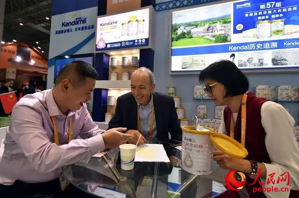McMahon (central) and his Chinese partners talk about details of a product. Photo by Weng Qiyu from People’s Daily Online