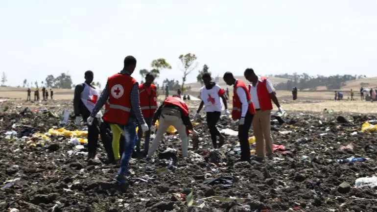 Des équipes de la Croix Rouge inspectant les débris du vol de la Ethiopian Airline qui s'est écrasé près d'Addis-Abeba (Ethiopie), le 10 mars 2019. (MICHAEL TEWELDE / AFP)