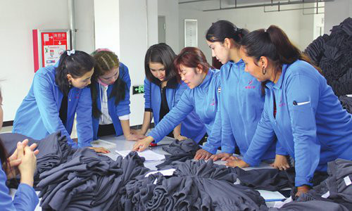 Workers in a clothing factory exchange experiences in Aksu prefecture, Northwest China's Xinjiang Uyghur Autonomous Region on February 19. Photo: Liu Xin/GT