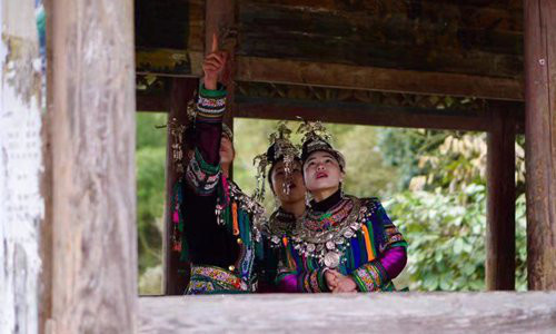 Members of Qixiannv are chatting on Fengyu Bridge, a unique architecture of the Dong ethnic group. (Photo from Global Times)