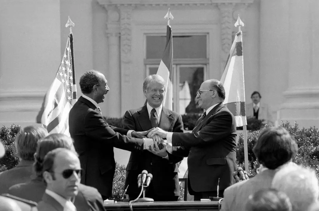 Le président égyptien Anouar el-Sadate, le président américain Jimmy Carter et le Premier ministre israélien Menahem Begin (de gauche à droite) se donnent une poignée de main groupée après avoir signé le traité de paix entre l’Égypte et Israël en 1979. (© AP Images)