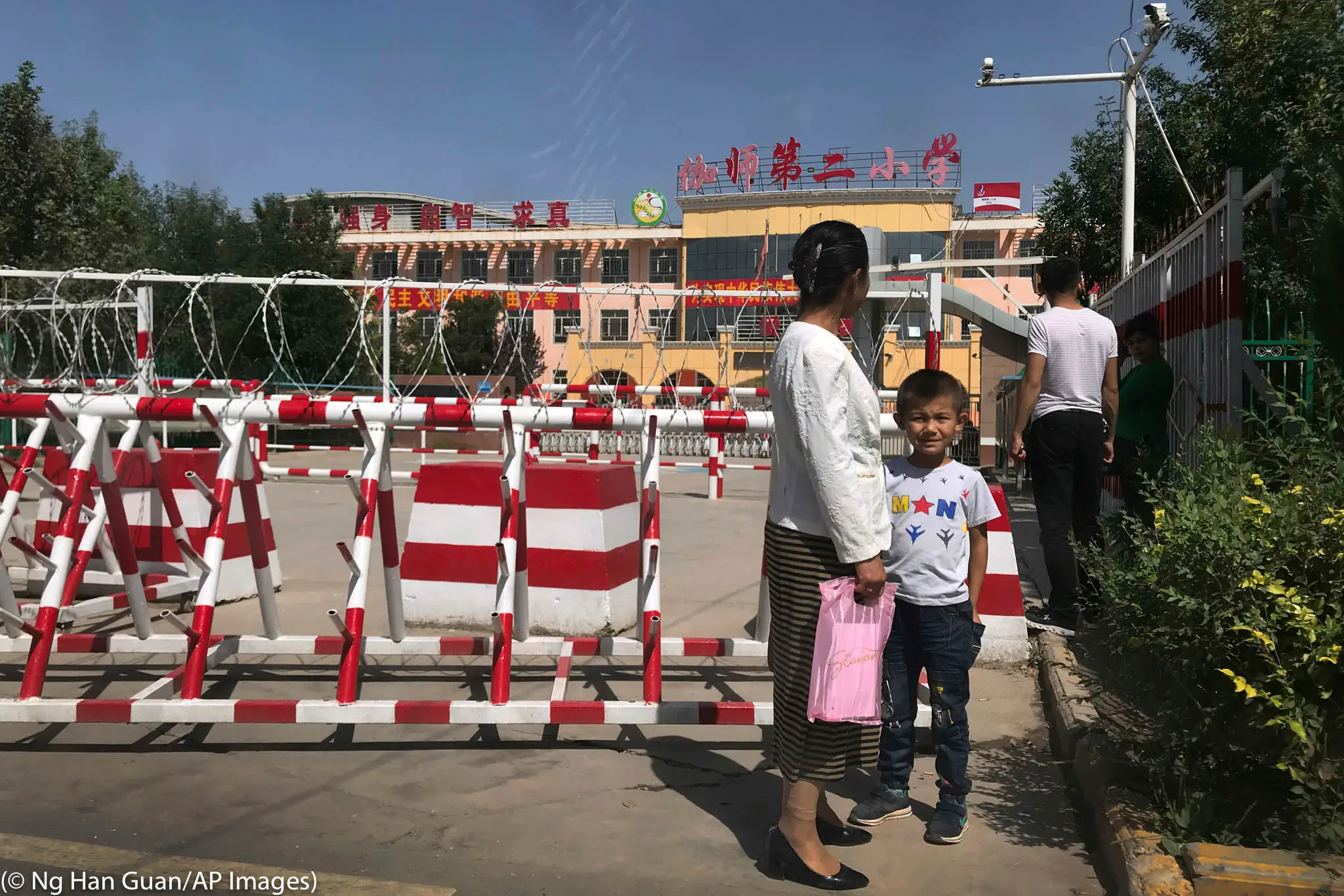 Les écoles fréquentées par les minorités au Xinjiang sont protégées par une kyrielle de caméras, de fils barbelés et de barrières. (© Ng Han Guan/AP Images)